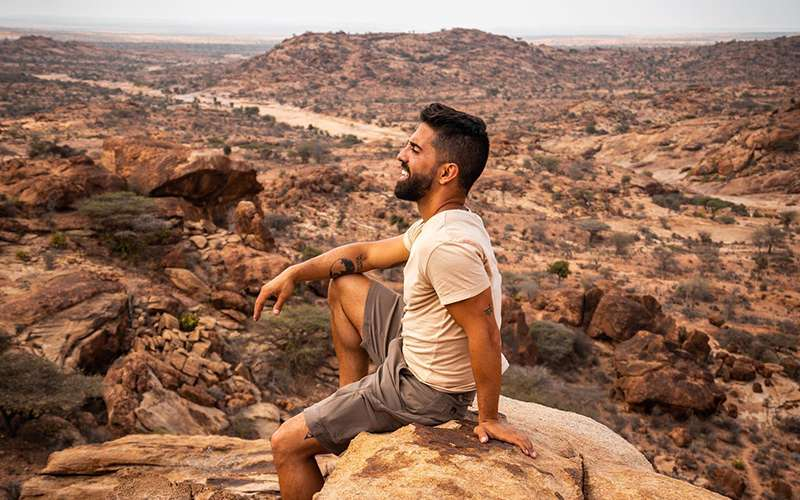 Alvaro Rojas sits on an outcropping of rock looking out into the distance on Socotra Island in Yemen.